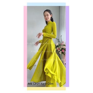 Puede incluir: Un vestido largo de manga larga de color verde lima con cuello alto y falda dividida. El vestido está hecho de una tela sedosa y tiene un corpiño ajustado. El vestido está fotografiado en una modelo sobre un fondo blanco. El texto "Mã: CF01 Xanh Cốm" está impreso en la parte inferior de la imagen.