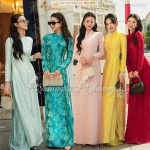 May include: Five women modelling long, flowing áo dài dresses in light green, teal, pink, yellow, and red. Each dress has a high collar and long sleeves. The dresses feature floral patterns and are paired with small handbags.