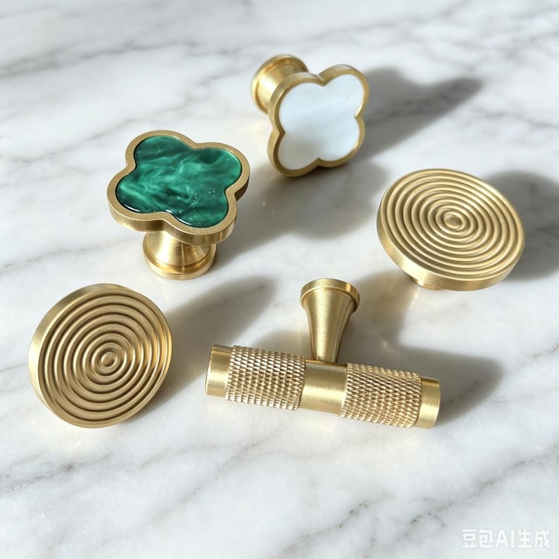 Peut inclure: Un ensemble de cinq boutons et poign&eacute;es de placard en laiton. Deux boutons sont circulaires avec des cercles concentriques, un poss&egrave;de une incrustation tr&egrave;fle en marbre vert, un autre une incrustation tr&egrave;fle blanche, et un est une barre en T molet&eacute;e.