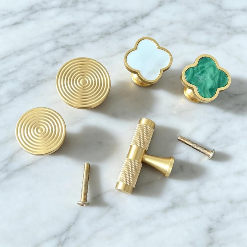 Peut inclure: Un ensemble de quincaillerie d'ameublement comprenant deux boutons ronds en laiton avec des motifs de cercles concentriques, un bouton en forme de tr&egrave;fle avec incrustation blanche, un bouton en forme de tr&egrave;fle avec incrustation verte et deux vis.