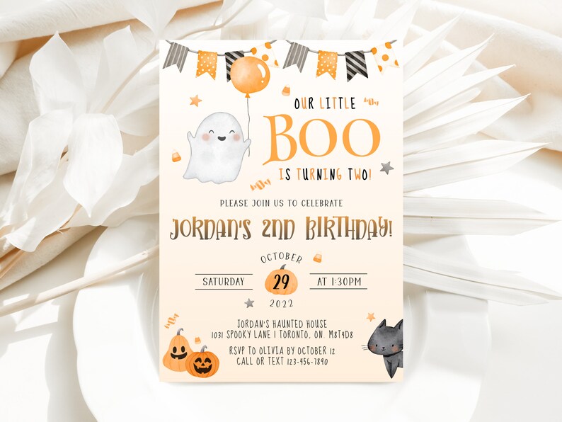 May include: Orange and black Halloween birthday invitation with a ghost, a black cat, and pumpkins. The text reads "Our Little Boo is turning two!" and "Jordan's 2nd Birthday!"  The invitation includes the date, time, and location of the party.