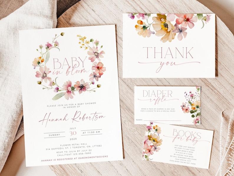 Peut inclure: Un ensemble d'invitations de f&ecirc;te pr&eacute;natale sur le th&egrave;me floral. Les invitations sont imprim&eacute;es sur du papier cartonn&eacute; blanc avec des fleurs d'aquarelle roses et jaunes. Le texte sur les invitations indique "Baby in Bloom" et comprend le nom "Hannah Robertson", la date et l'heure de la f&ecirc;te pr&eacute;natale, ainsi que le lieu. Les invitations comprennent &eacute;galement une carte de remerciement et deux cartes pour une tombola de couches et une demande de livres.