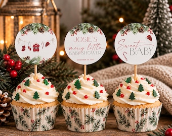 Può includere: Tre cupcake con glassa bianca, zuccherini a forma di albero verde e perle di zucchero rosse in pirottini con motivo di pino. Ognuno ha un topper circolare: uno con un grafico di un filo da bucato, uno con JOSIE'S merry little BABY SHOWER e uno Sweet BABY.