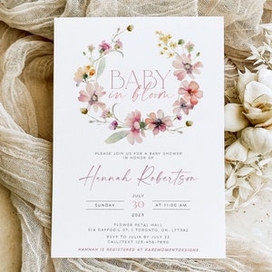 Peut inclure: Une invitation &agrave; une f&ecirc;te pr&eacute;natale avec une couronne florale aquarelle et le texte "BABY in bloom". L'invitation est pour Hannah Robertson et est pr&eacute;vue pour le dimanche 30 juillet &agrave; 11h00. L'&eacute;v&eacute;nement aura lieu au Flower Petal Hall, 514 Daffodil St., Toronto, ON. L7T582. RSVP &agrave; Julia avant le 22 juillet. Appelez/textez au 123-456-7890. Hannah est inscrite chez Raremomentdesigns.