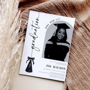Op de afbeelding: Een afstudeeraankondiging met een zwart-wit foto van een lachende persoon met een afstudeerhoed. De tekst luidt "Graduation" en "She Did It!" met details voor de ceremonie, inclusief de naam, datum, tijd en locatie.