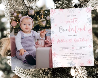 Peut inclure: Une invitation de fête de premier anniversaire sur le thème des flocons de neige rose et argent. L'invitation indique "Rejoignez-nous dans un pays des merveilles d'hiver pour célébrer le 1er anniversaire de Millie !" avec la date et l'heure de la fête indiquées ci-dessous.