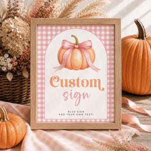 Puede incluir: Un marco de madera rectangular que contiene un letrero con fondo de cuadros vichy rosa y blanco. El letrero presenta una ilustración de una calabaza color melocotón con un lazo rosa, el texto Custom sign y 8x10 SIGN ADD YOUR OWN TEXT!