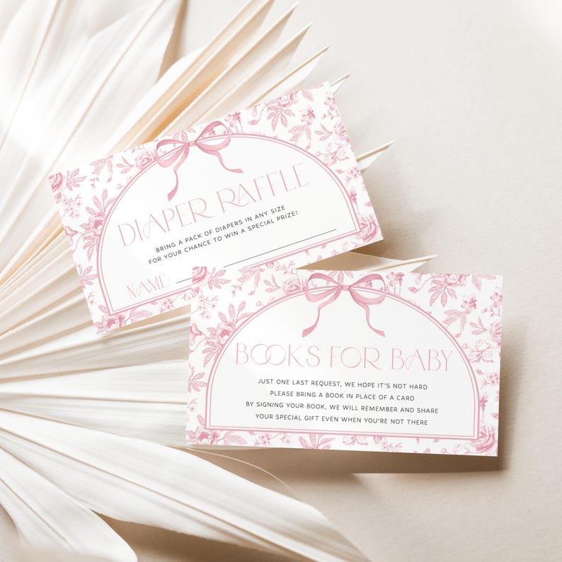 May include: Two baby shower cards with pink floral designs and text. One card reads "Diaper Raffle" and the other says "Books for Baby". Both cards have a bow graphic at the top and are on a white background.