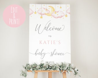 May include: A white welcome sign with pink clouds, stars, and a crescent moon. The text reads "Welcome to Katie's Baby Shower 08.27.23".