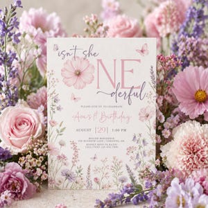 May include: A rectangular birthday invitation card featuring a floral design with pink and purple wildflowers and butterflies. The text reads: isn't she ONEderful, PLEASE JOIN US TO CELEBRATE, Ava's 1st Birthday, AUGUST 29 1:00 PM, MILLER RESIDENCE, 430 BLOSSOM LANE.