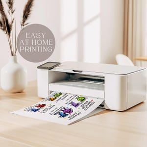 May include: A white printer is printing a sheet of paper with colorful cartoon characters and text. The text on the paper includes phrases like "School is 67 times better with you" and "How your day is a solid". The image also includes the text "Easy at home printing".