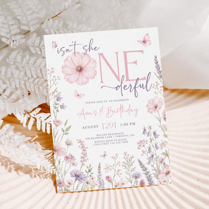 May include: A white rectangular birthday invitation card featuring pink and purple floral illustrations, butterflies, and the text: isn't she ONEderful, PLEASE JOIN US TO CELEBRATE, Ava's 1st Birthday, AUGUST 29, 1:00 PM, MILLER RESIDENCE, 430 BLOSSOM LANE, TORONTO, ON.