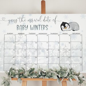 K&ouml;nnte beinhalten: Ein wei&szlig;er Kalender mit einem blauen und wei&szlig;en Schneeflockenmuster. Der Kalender tr&auml;gt den Titel "Erraten Sie das Ankunftsdatum von Baby Winters". Der Kalender hat eine Pinguin-Illustration in der oberen rechten Ecke.