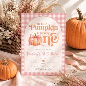 Può includere: Un biglietto d'invito di compleanno rettangolare con un bordo a quadretti vichy rosa e bianco. Il testo recita: our little Pumpkin is turning one, Kinsley's 1st Birthday, October 26, 2026, Saturday at 1:00 PM, Maple Grove Pumpkin Patch, Toronto, ON.
