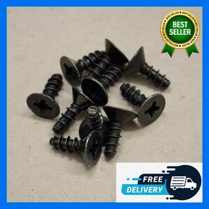 Puede incluir: Un conjunto de tornillos negros con cabezas planas y ranuras en cruz. Los tornillos están esparcidos sobre una superficie de color claro. También se ve una pegatina de "Más vendido" y un gráfico de "Entrega gratuita".