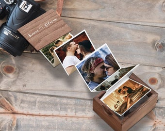 May include: A wooden photo album with a personalized inscription "Kevin & Olivia" on the cover. The album is open, revealing a series of photos of a couple.