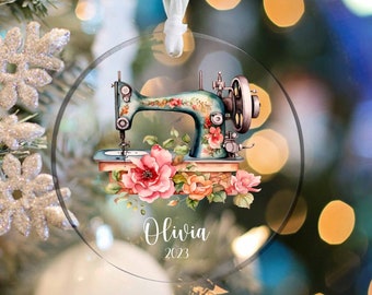 May include: A round glass ornament with a vintage sewing machine and floral design. The ornament is personalized with the name "Olivia" and the year "2023".