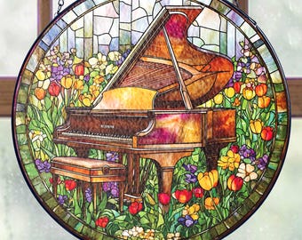 Peut inclure: Une fenêtre en verre teinté suspendu avec un cadre rond représentant un piano à queue dans un jardin avec des fleurs colorées. Le piano est brun avec un clavier noir et un banc blanc. Les fleurs sont rouges, jaunes, orange, violettes et roses.