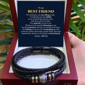 May include: A black leather bracelet with silver and gold accents comes in a red box with a heartfelt message for a best friend. The message reads, "To my BEST FRIEND If I could give you one thing in life, I would give you the ability to see yourself through my eyes, only then will you realize how special you are to me. Thank you for actually listening to me. For being honest with me even if the trust hurts. For letting me be me. For reminding me that it doesn't matter what other people think. But most importantly, thank you for being my best friend. Love, Olivia."