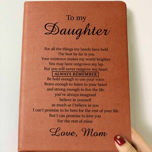 May include: A brown leather journal with a heartfelt message to a daughter from her mother. The message includes the words "To my Daughter", "Always Remember", and "Love, Mom".