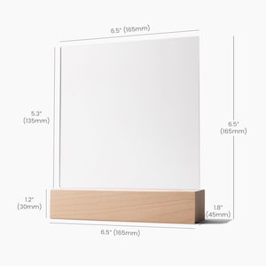 May include: A clear acrylic sign holder with a wooden base. The sign holder is 6.5 inches tall and 5.3 inches wide. The base is 1.8 inches tall and 6.5 inches wide.