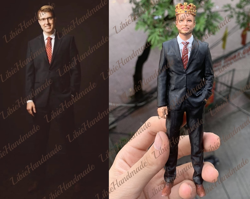 May include: A 3D-printed figurine of a man in a black suit, red tie, and a gold crown. The figurine is held in a hand. The image also shows a photograph of a man in a black suit and red tie.