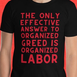May include: A black t-shirt with the text "THE ONLY EFFECTIVE ANSWER TO ORGANIZED GREED IS ORGANIZED LABOR" printed in red.