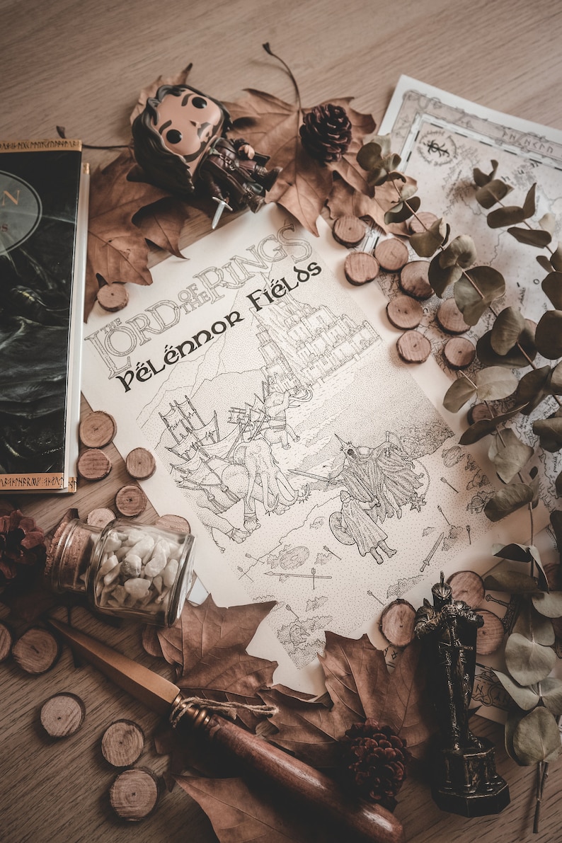 May include: A close-up of a Lord of the Rings themed illustration featuring the text "Lord of the Rings Pelennor Fields". The illustration depicts a battle scene with figures and horses. The illustration is surrounded by autumn leaves, wooden discs, a small figurine, and a glass jar filled with white stones.