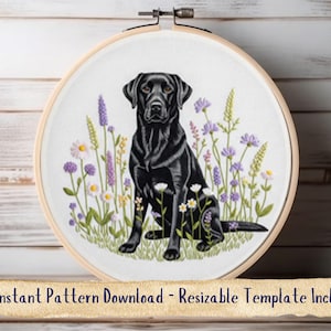 May include: Embroidery hoop featuring a black Labrador Retriever surrounded by wildflowers in shades of purple, white, and green. The dog is sitting in a field of flowers. The hoop is made of wood and has a metal clasp.