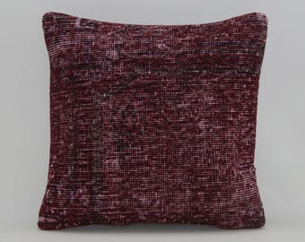 May include: A burgundy throw pillow with a woven texture. The pillow is made from a soft, comfortable fabric and has a subtle distressed look.