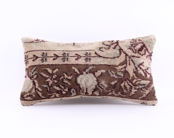 May include: A rectangular cushion with a brown and beige patterned fabric. The pattern features floral designs and intricate details.