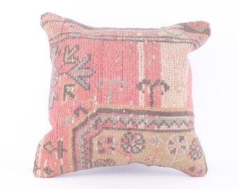 May include: A pink and gray patterned throw pillow with a traditional design. The pillow is made of woven fabric and has a square shape.