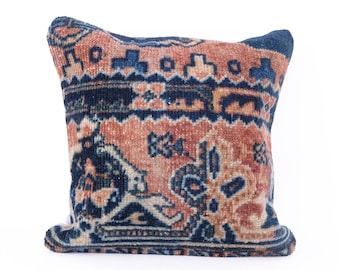 May include: A decorative pillow with a blue and orange patterned design. The pillow is made from a woven fabric with a traditional rug-like pattern.