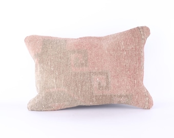 May include: A rectangular pink and beige throw pillow with a woven texture.