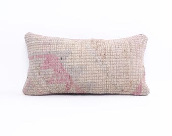 May include: A rectangular throw pillow with a white and pink woven pattern. The pillow is made of a soft, textured fabric.