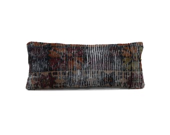 May include: Rectangular cushion with a vintage rug design. The cushion features a mix of colours including brown, red, black, and white. The design has a striped pattern with floral accents, suitable for home decor.