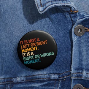 May include: A black button with a rainbow gradient design. The text on the button reads "It is not a left or right moment. It is a right or wrong moment."