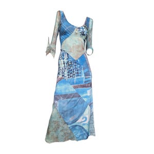 Peut inclure: Longue robe bleue avec un design patchwork unique. La robe présente un décolleté en V et des manches longues avec des détails de nœuds. Le patchwork incorpore diverses nuances de bleu et des motifs abstraits.