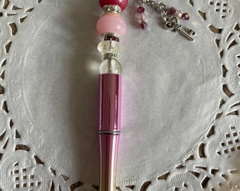 Stylo à billes rétractable que j’ai décoré avec une perle en résine époxy et d’autres perles assorties, et sa petite chaîne décorée!