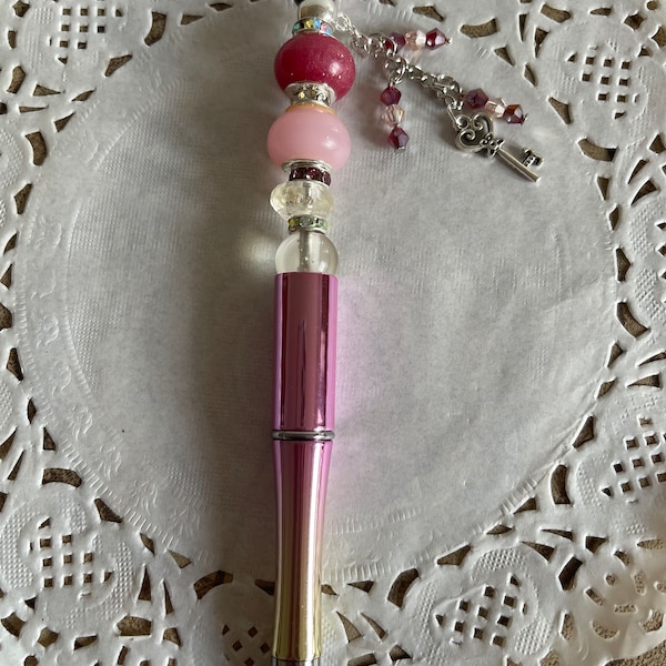 Stylo à billes rétractable que j’ai décoré avec une perle en résine époxy et d’autres perles assorties, et sa petite chaîne décorée!