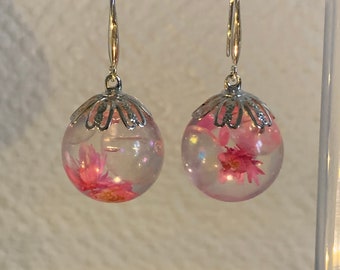 Magnifique boucles d’oreilles en forme de boules transparentes réalisées en résine époxy et fleurs séchées de couleur rose ! Fait main