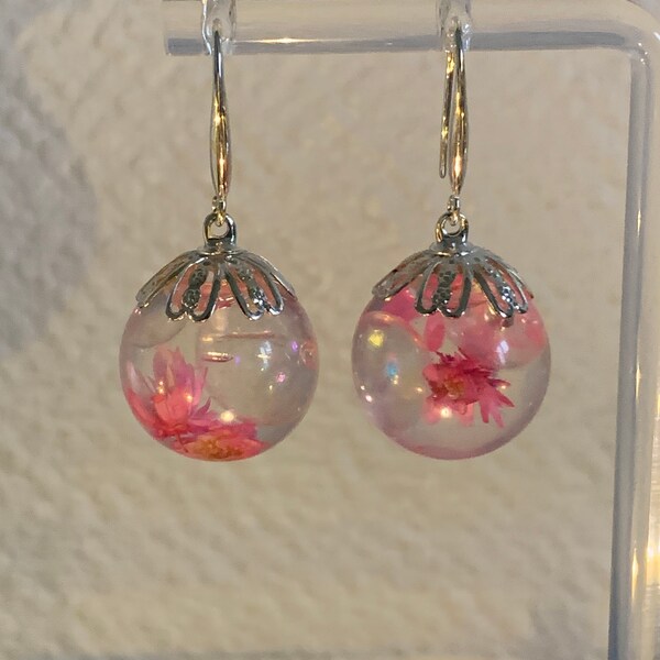 Magnifique boucles d’oreilles en forme de boules transparentes réalisées en résine époxy et fleurs séchées de couleur rose ! Fait main