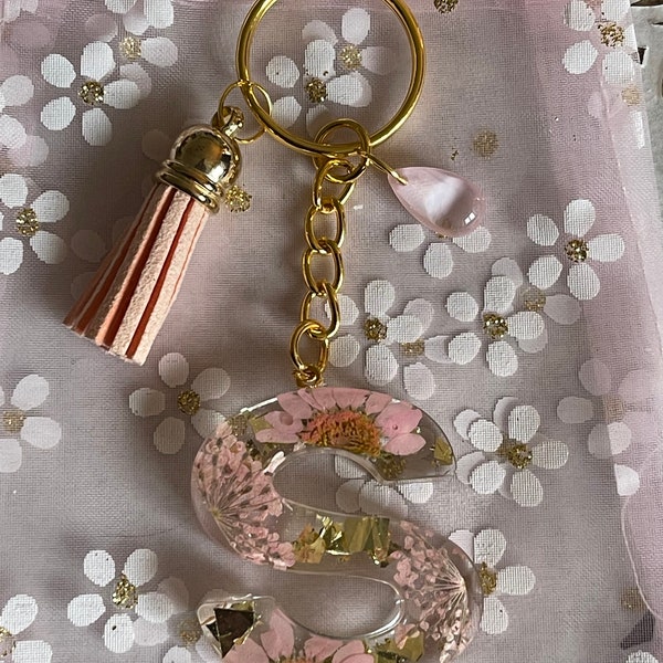 Porte clés ou bijoux de sac lettre S fabriqué en résine époxy de haute qualité avec des fleurs séchées et des feuilles d’or ! Fait main