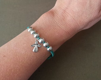 Suede bracelet with a metal angel.An ornament on the arm.A gift for Angel's Day.Jewelry.Decoration.Gift.Souvenir.Goods for the church shop