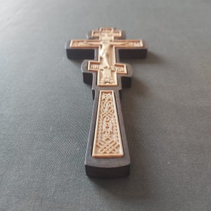Hand-carved wooden cross. The cross is tonsured. Paramannyj cross. The monk. The altar cross. Cross in the hand.Crosses and church utensils.