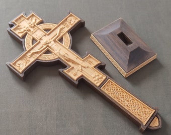 The altar cross on a stand.The altar cross.Cross in hand.Crosses and church utensils.The priest's cross on the throne.Easter cross.Handmade.