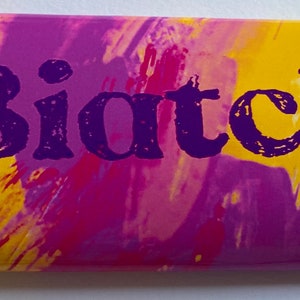 Op de afbeelding: Een abstracte achtergrond in paars en geel met het woord "Biatch" in paars gedrukt.