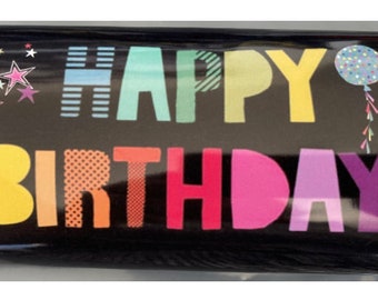 Può includere: Una tavoletta di cioccolato fondente con un involucro dorato. L'involucro presenta un messaggio colorato "Buon compleanno" con stelle e un palloncino.