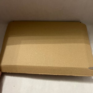 May include: A brown cardboard box with a textured surface. The box is open and empty.