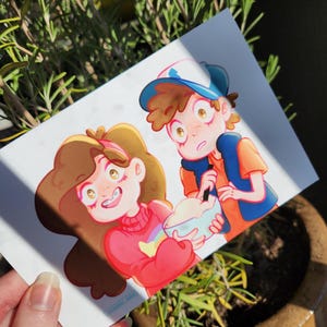 May include: A colorful illustration of two cartoon characters, a girl in a red sweater with a rainbow and a boy in a blue hat and vest. The girl is smiling, and the boy is holding a bowl. The artwork is on a white card.